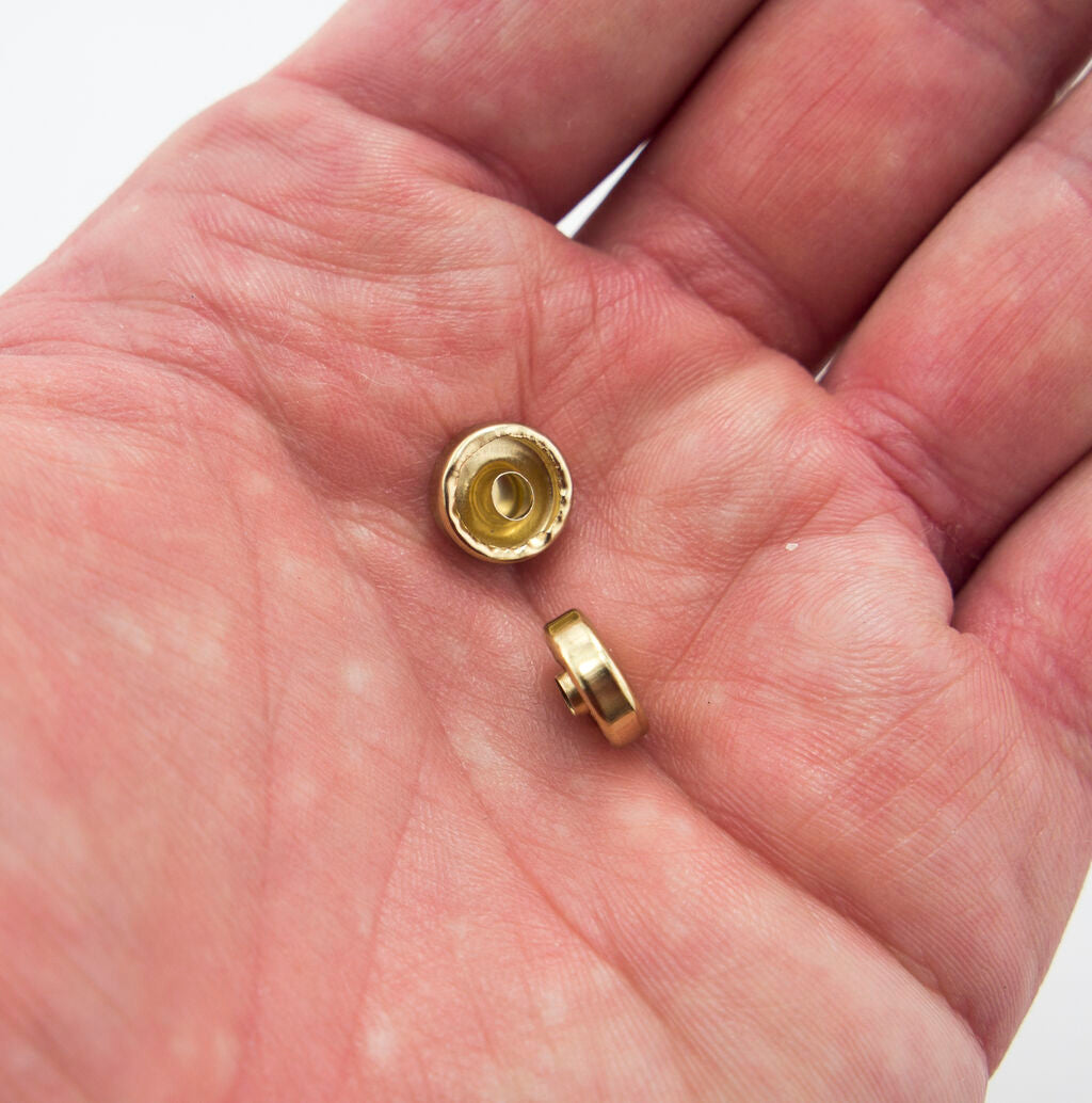 Variety of press studs in light brass tone arranged neatly