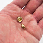 Variety of press studs in light brass tone arranged neatly