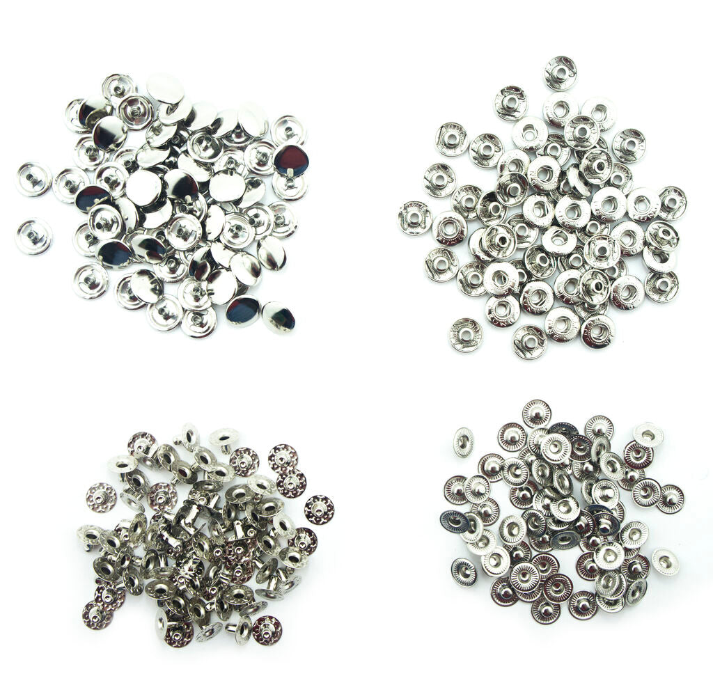 Close-up of silver tone 4-part press stud buttons on a white background.