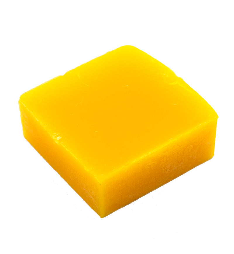 Block of tailor's beeswax measuring 45 x 45 mm on a wooden surface.