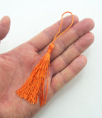Close-up of a dark orange silky tassel, ideal for craft projects.