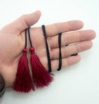 Close-up of red silky polyester tassels showing detail and length.