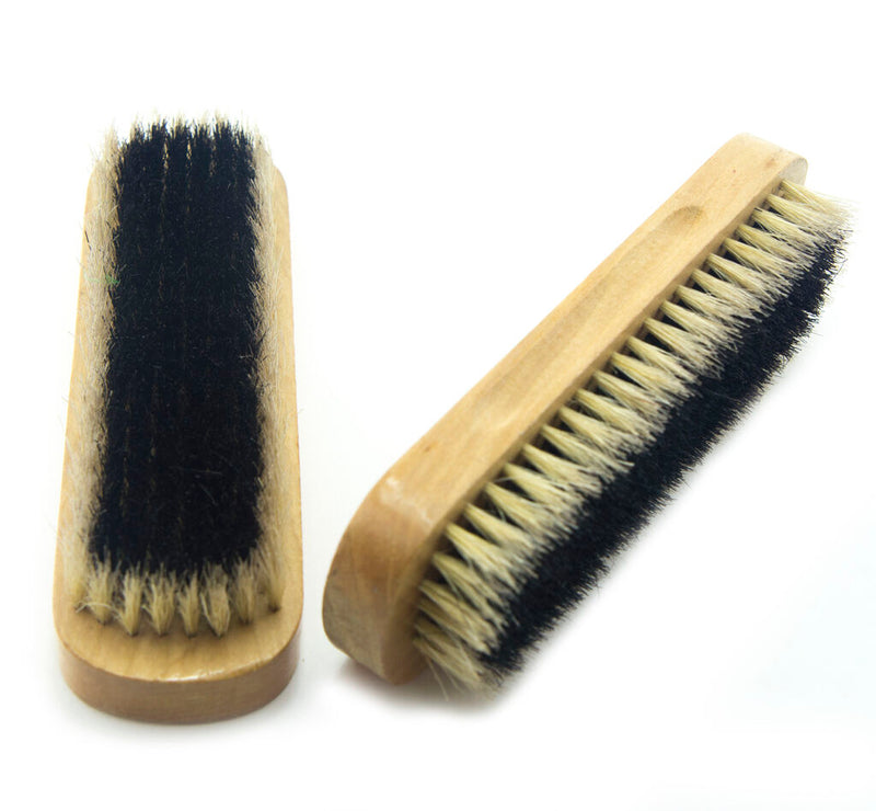 Two large solid wooden brushes for shoe care on a white background.