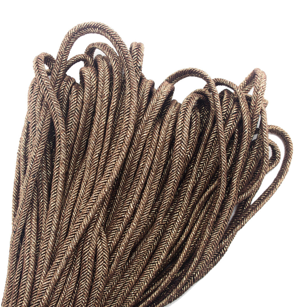Close-up of metallic bronze plait cord trim on a white background.