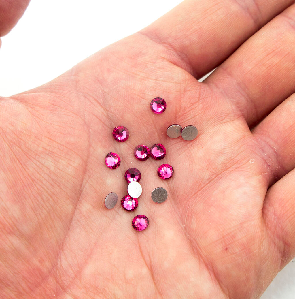 Close-up of 5 mm dark fuschia glass rhinestones for embellishment.