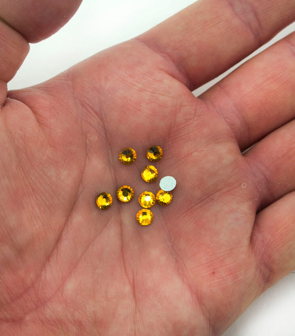 Close-up of 5 mm amber hot fix iron-on rhinestones.
