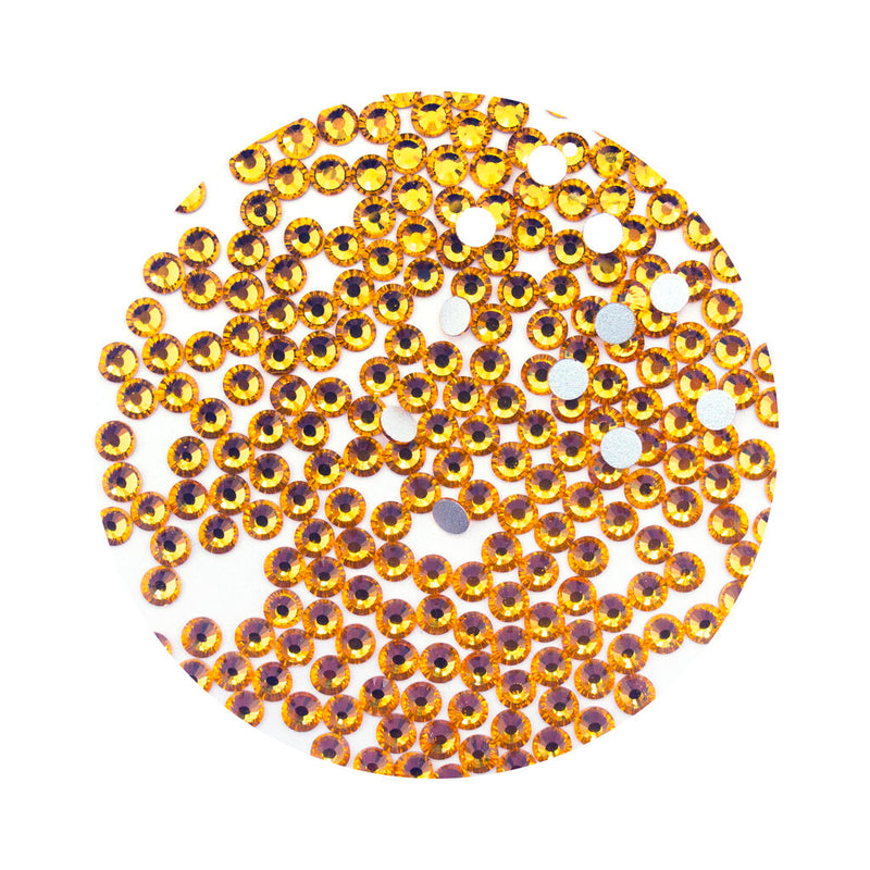 Pack of amber glass diamante rhinestones for garment decoration.