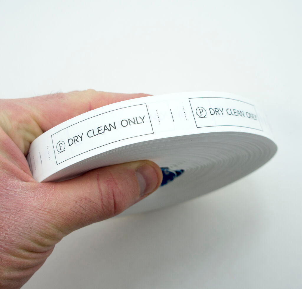 Close-up of a wash care label showing black text on white fabric.