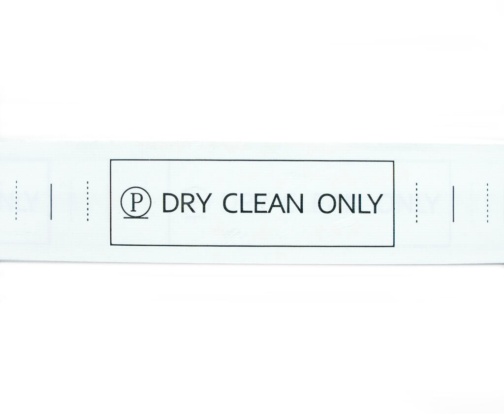 Roll of 2000 'DRY CLEAN ONLY' wash care labels on a table.