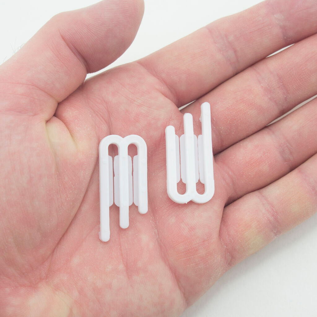 Close-up of a white plastic 3 prong shirt clip measuring 38 x 18 mm.