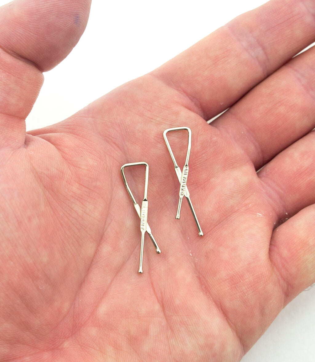 Close-up of a 32mm metal cross clip for garment display.