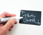 Markers in use on a blackboard displaying a menu in chalk effect.