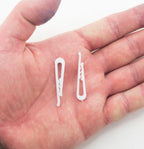Close-up of white plastic garment clips, size 40 x 8 mm.