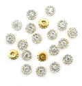 Pack of 20 small round white glass crystal embellishments in gold tone settings.