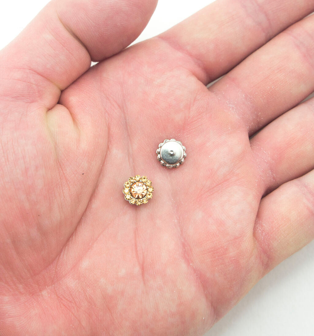 Close-up of a golden champagne glass crystal embellishment for sewing.