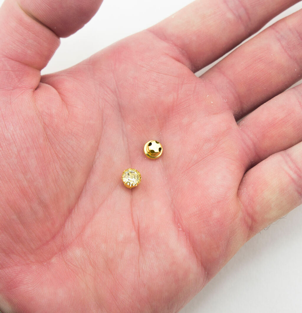 Gold tone setting of the round crystal embellishments