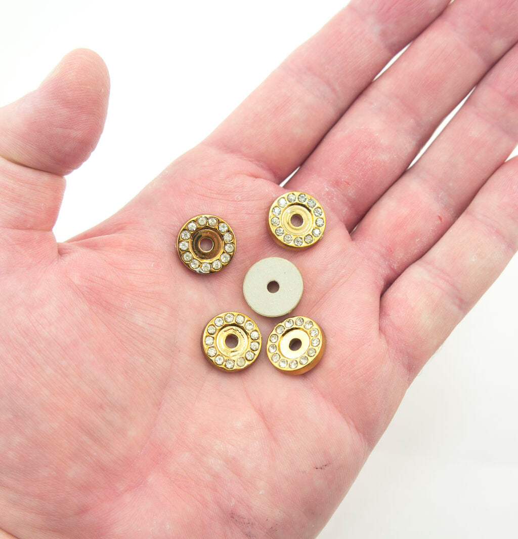 Display of round gold tone embellishments on a fabric