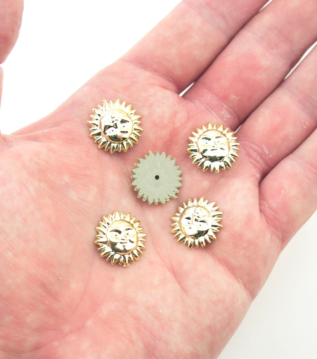 Close-up of gold tone sun face embellishment showing pin fix backing.