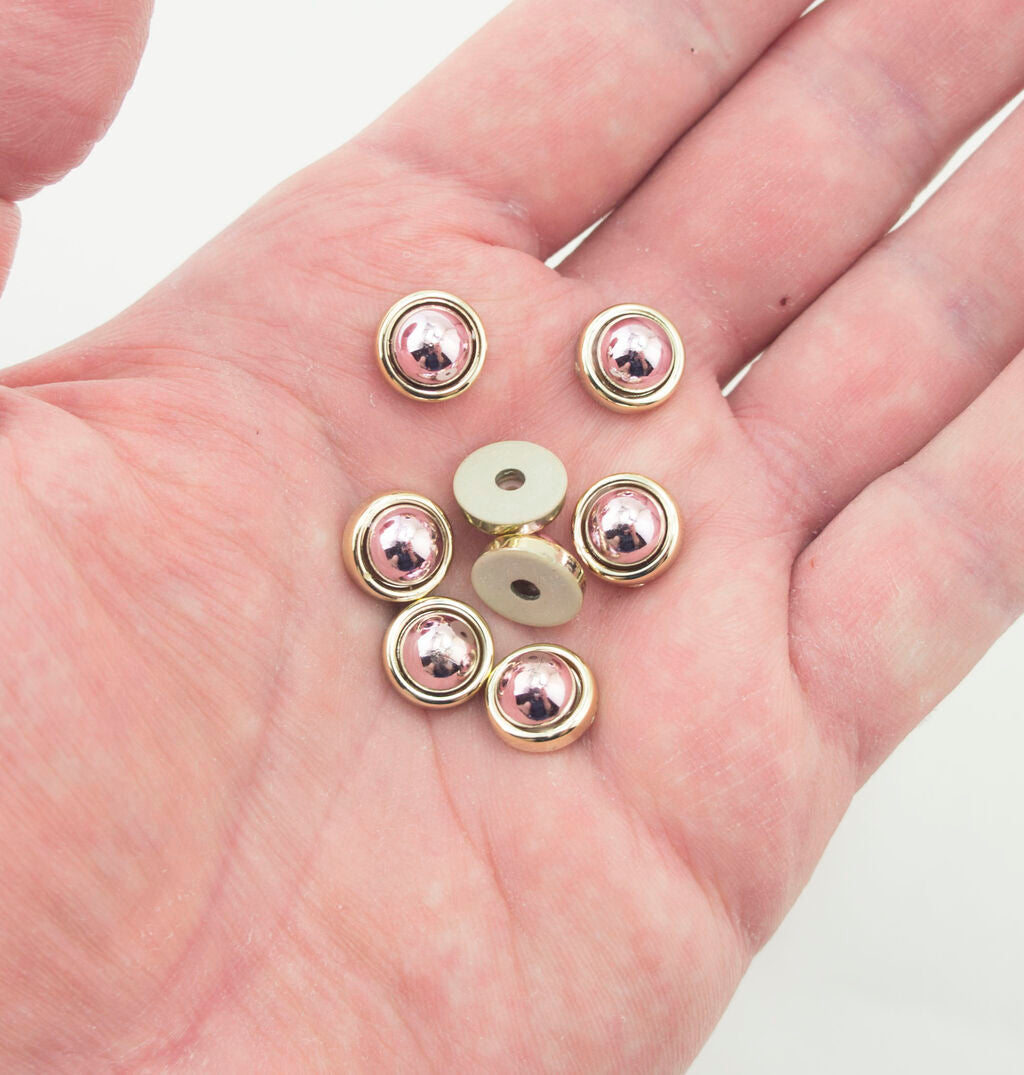 Close-up of round dome shaped embellishments in rose and gold tone.