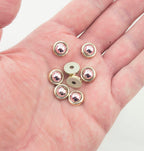 Close-up of round dome shaped embellishments in rose and gold tone.