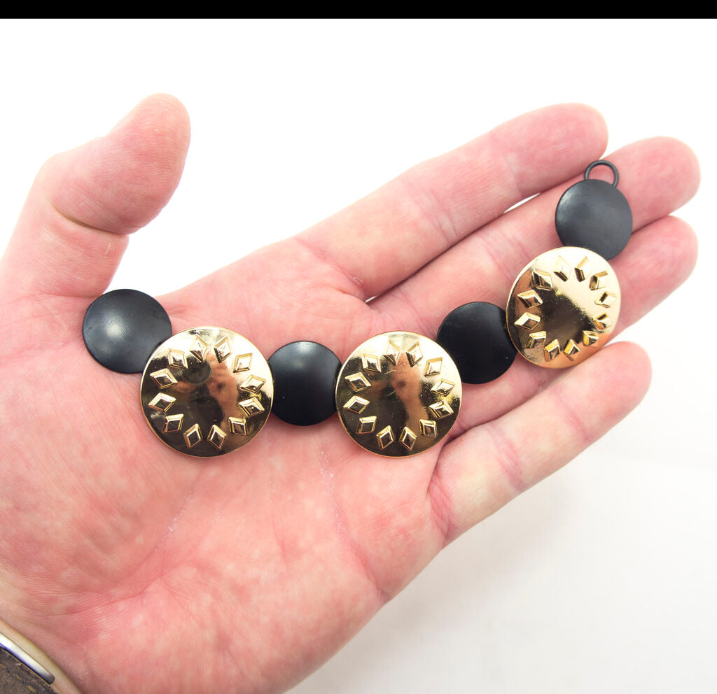 Set of 2 gold tone and black circular discs pendant chains arranged together.