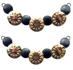 Gold tone and black circular discs pendant chain displayed on a white background.
