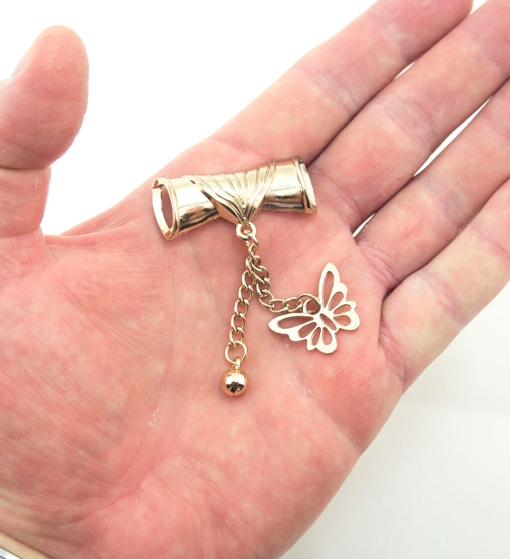 Close-up of the gold tone scroll and butterfly pendant showing intricate design.