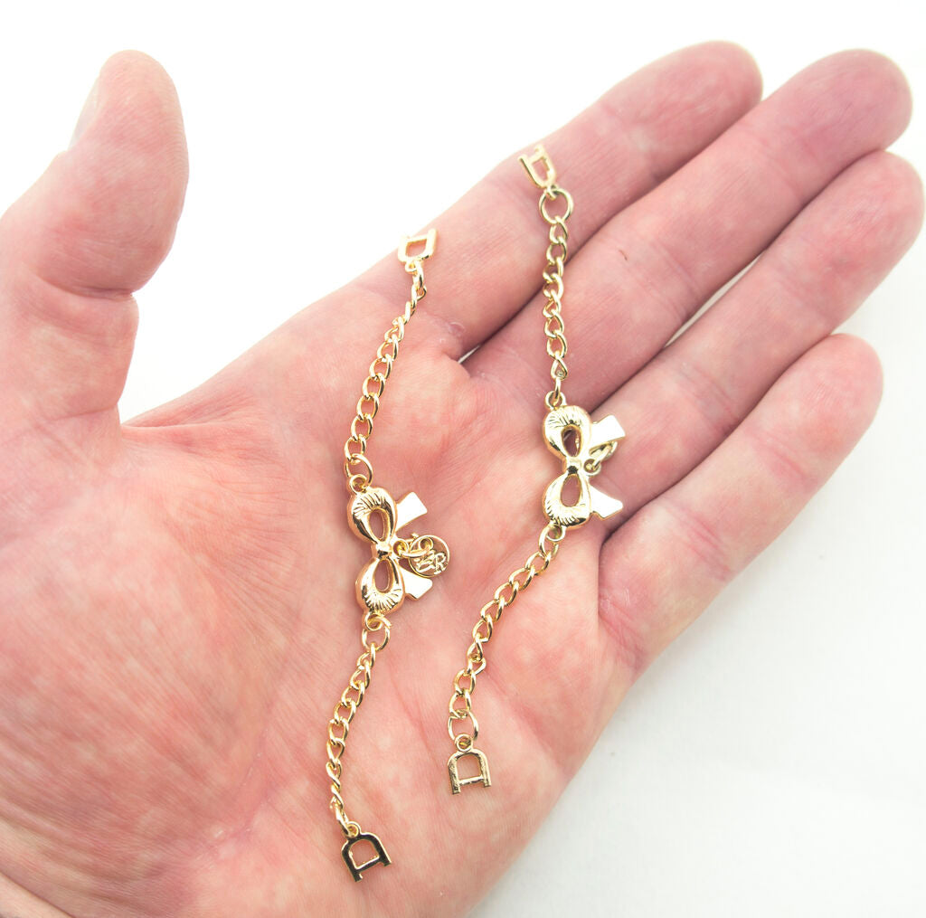 Close-up of the gold tone metal chain with bow detail.