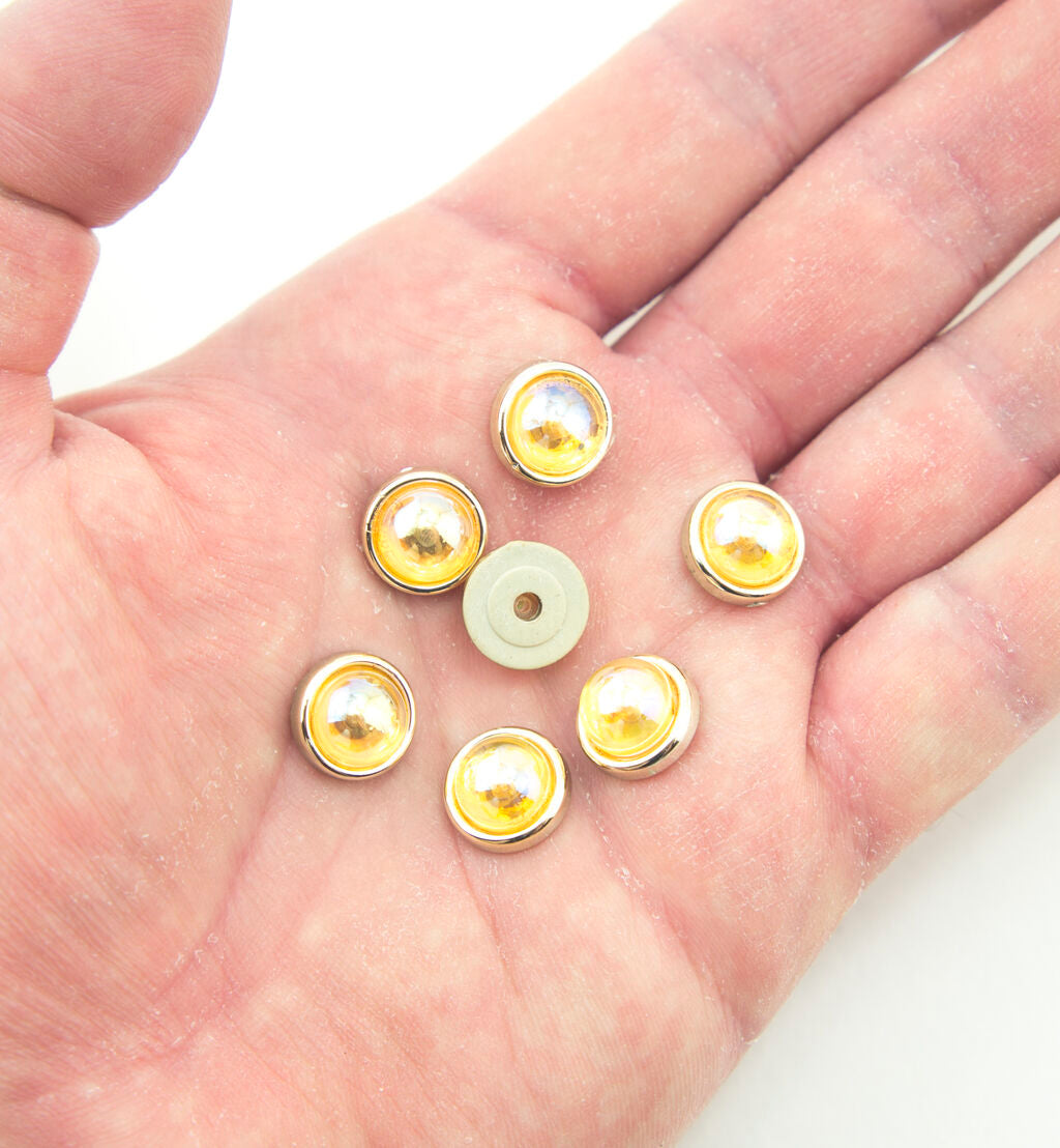 Close-up of a gold tone embellishment featuring amber-rose crystals.