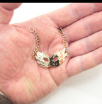Three gold tone metal party mask pendants displayed together.