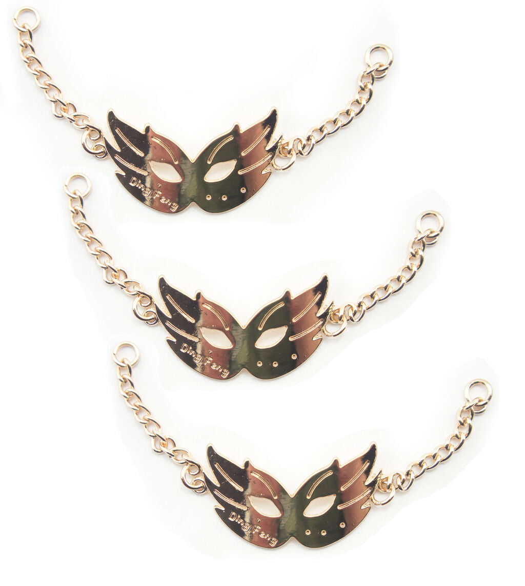 Gold tone metal party mask pendant with chain for embellishment.
