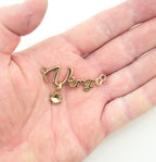 Close-up of a gold tone metal Virgo pendant showing detail and finish.
