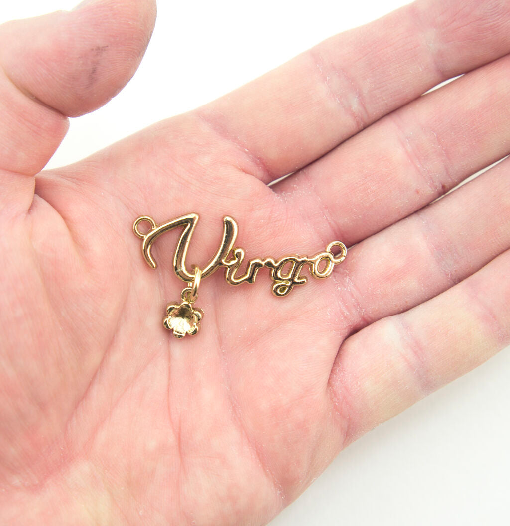 Close-up of a gold tone metal Virgo pendant showing detail and finish.