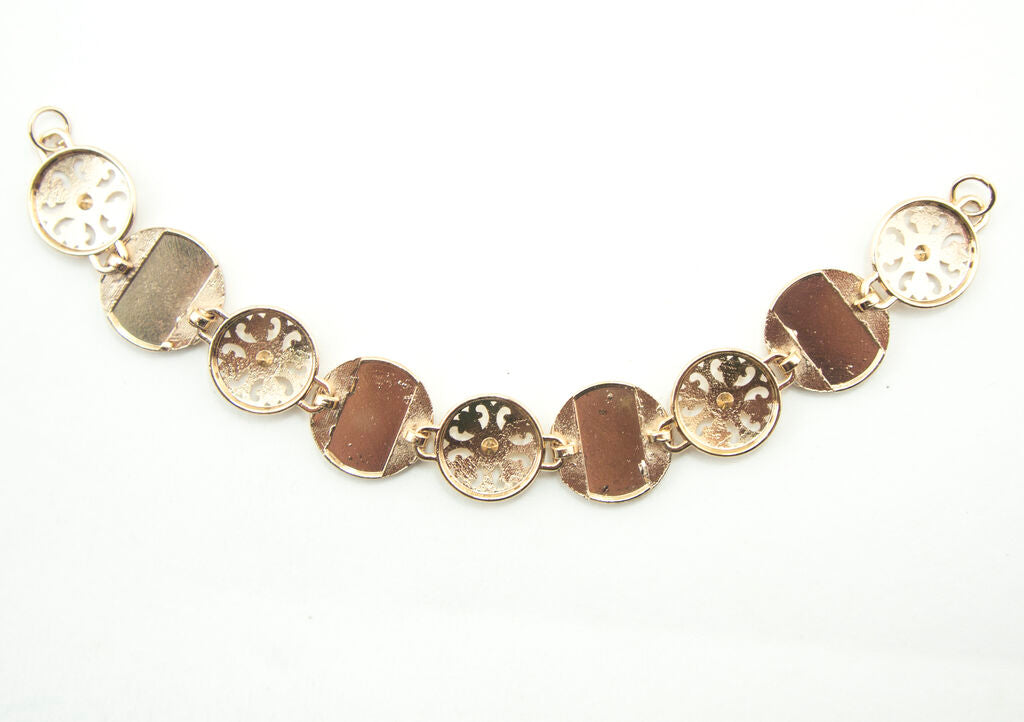 Close-up of the gold tone chain showing the white enamel detail.