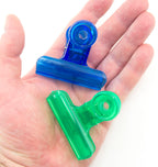 Assorted colours of plastic bulldog clips displayed together.