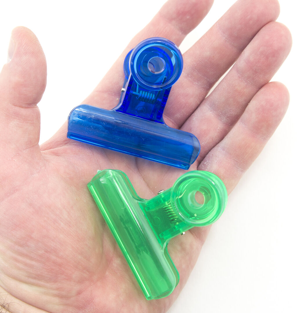 Assorted colours of plastic bulldog clips displayed together.