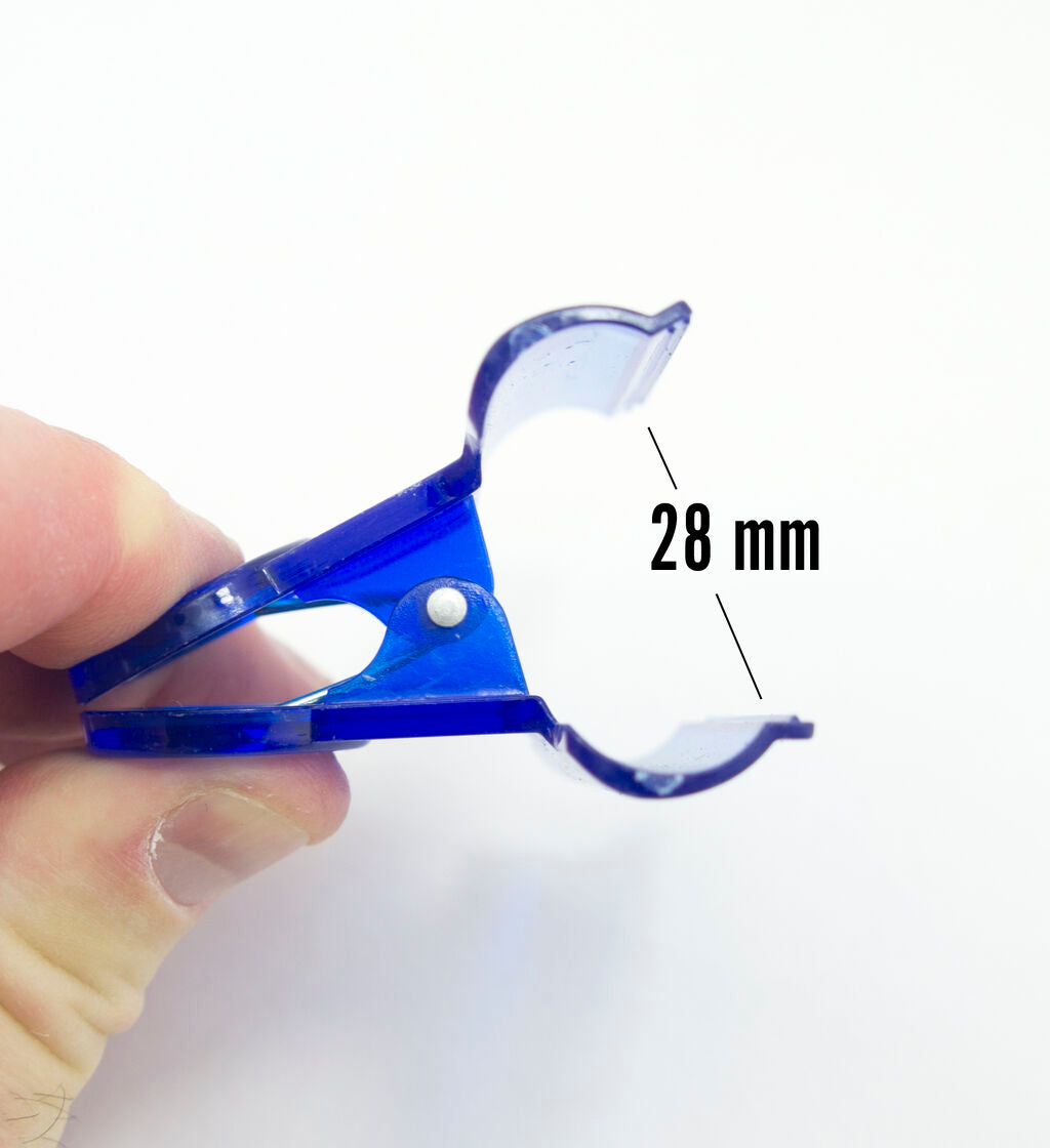 Close-up of a transparent bulldog clip holding sheets of paper.