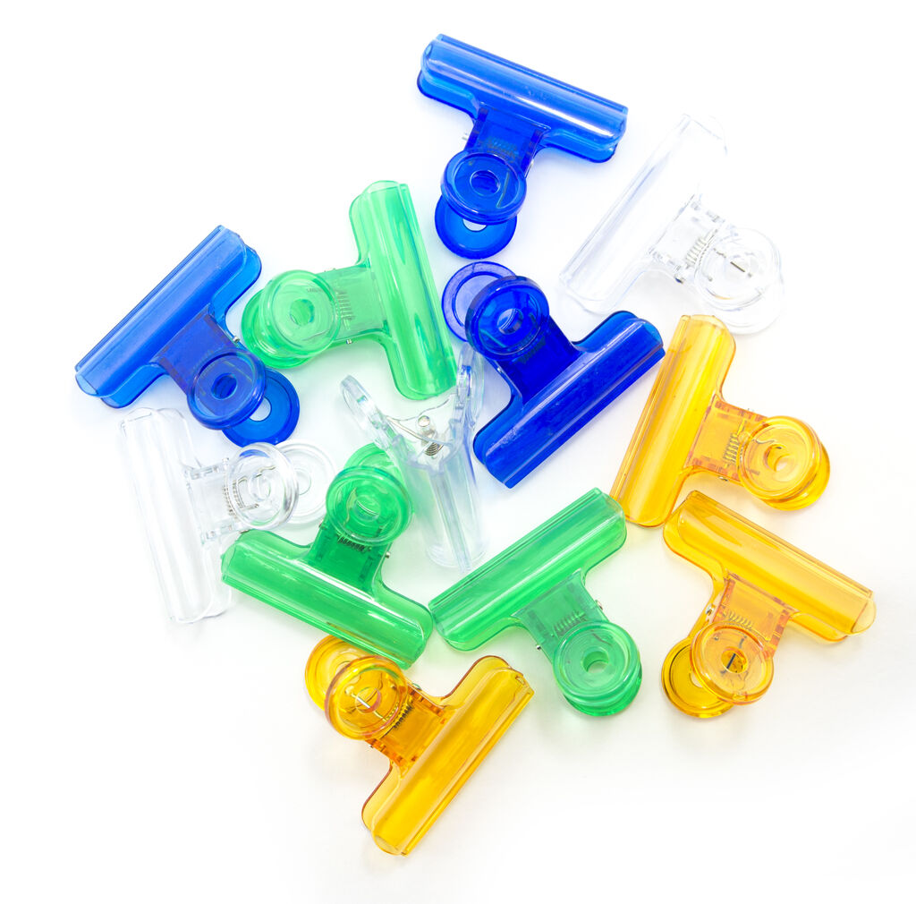 Pack of 12 colourful plastic bulldog paper clips on a white background.