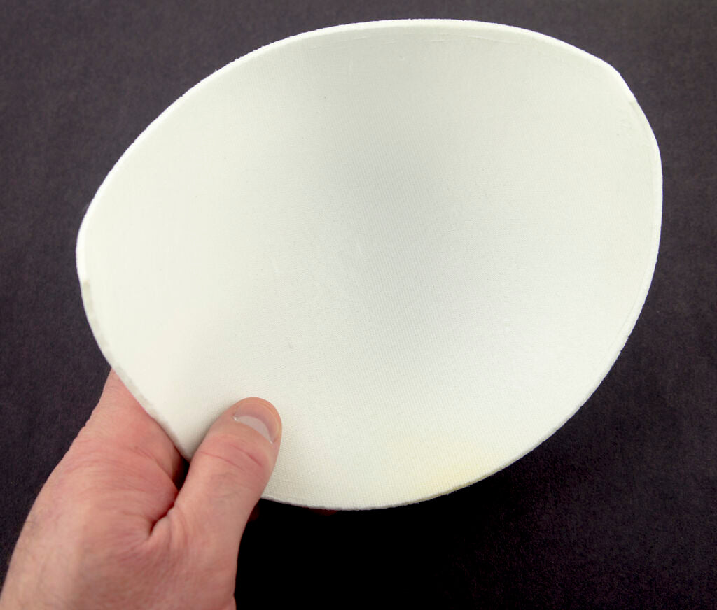 Close-up of soft 6XL white bra pads showing their curved shape.