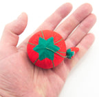 Emery used for sharpening pins next to a tomato pin cushion.