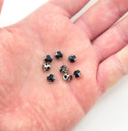 Close-up of a black round crystal sew in trim with metal mount