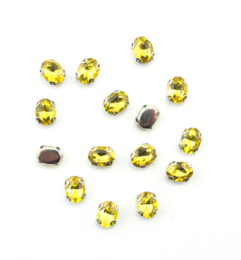 Set of 15 golden yellow oval crystal sew in trims displayed.