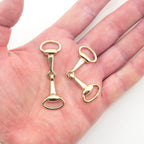 Close-up of gold tone equestrian buckles, 60 x 20 mm size.