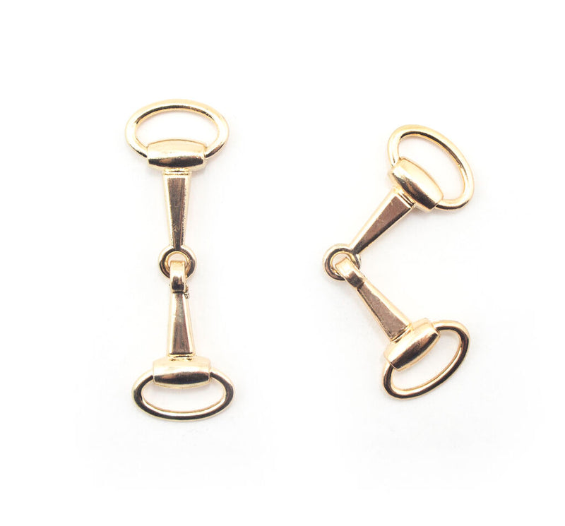 Pair of gold tone equestrian buckles for bags and footwear.