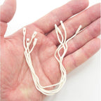 Close-up of round snap locks on off white cotton hang tags.