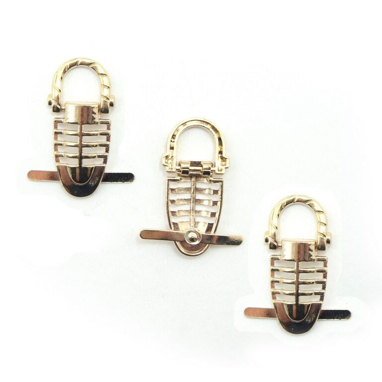 Gold-tone trilobite pin on embellishments for leather goods.