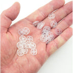 Close-up of 12 mm clear plastic press stud buttons in a set.