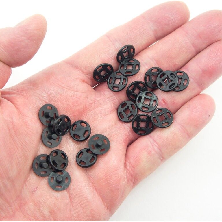 Close-up of 12 mm black plastic press stud buttons for sewing.