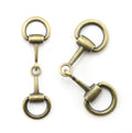 Antique gold equestrian buckle displayed on a white background.