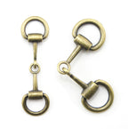 Antique gold equestrian buckle displayed on a white background.